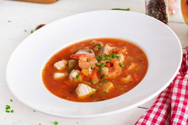 Brezilya gıda: balık ve biber baharatlı Hindistan cevizi soslu Beyaz ahşap bir masa üzerinde bir tabak içinde Moqueca capixaba. Brezilyalı balık güveç.