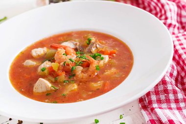 Brezilya gıda: balık ve biber baharatlı Hindistan cevizi soslu Beyaz ahşap bir masa üzerinde bir tabak içinde Moqueca capixaba. Brezilyalı balık güveç.