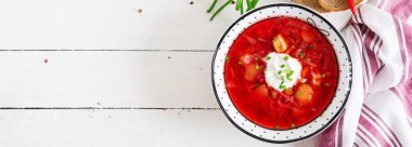 Kupa Beyaz fasulye ile geleneksel Ukraynalı Rus borsch. Pancar çorbası. Kırmızı pancar kök çorbası borsch beyaz masaya tabak. Geleneksel Ukrayna yemek mutfağı. Üstten görünüm