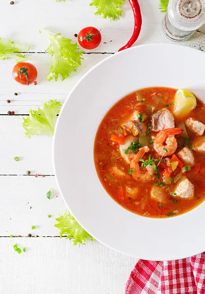 Brazilian food: Moqueca capixaba of fish and bell peppers in spicy coconut sauce in a plate on a white wooden table. Brazilian fish stew. Top view — Stock Image Brazilian Food Moqueca Capixaba Fish Bell Peppers Spicy Coconut Sauce Royalty Free Stock Images