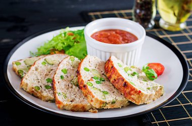 Lezzetli ev yapımı zemin tavuk köfte yeşil bezelye ve brokoli siyah tablo ile pişmiş. Gıda Amerikan köfte.