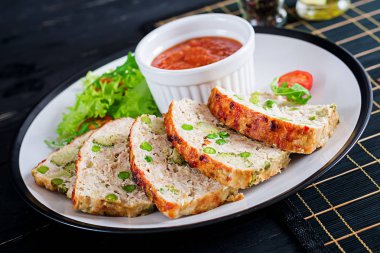 Lezzetli ev yapımı zemin tavuk köfte yeşil bezelye ve brokoli siyah tablo ile pişmiş. Gıda Amerikan köfte.