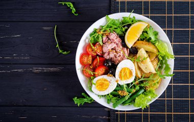 Ton balığı, yeşil fasulye, domates, yumurta, patates, siyah zeytin yakın çekim masada bir kasede sağlıklı bol salata. Salata salata. Fransız mutfağı. Üstten görünüm. Düz yatıyordu