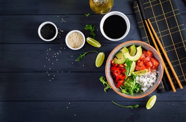 Hawaii somon balığı kasesi, pilav, avokado, paprika, susam tohumu ve limon. Buda kasesi. Diyet yemek. Üst görünüm