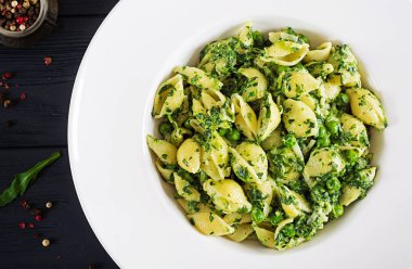 Conchiglie makarna ıspanak ve yeşil bezelye pesto ile. İtalyan mutfağı. Vegan gıda. Üstten görünüm