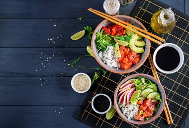 Pirinç, avakado, kırmızı biber, salatalık, turp, susam ve kireç ile Hawaiian Somon Balık poke kase. Buda kase. Diyet yemekleri. Üstten görünüm