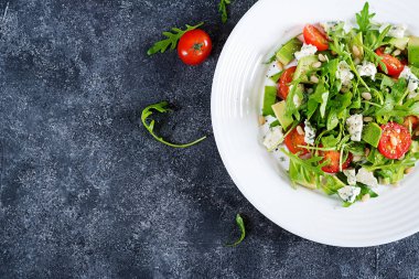 Diyet salata domates, mavi peynir, avokado, roka ve çam fıstığı. Üstten görünüm. Düz yatıyordu.