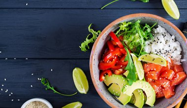 Hawaii somon balığı kasesi, pilav, avokado, paprika, susam tohumu ve limon. Buda kasesi. Diyet yemek. Üst görünüm