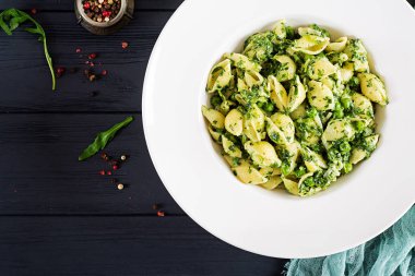 Conchiglie makarna ıspanak ve yeşil bezelye pesto ile. İtalyan mutfağı. Vegan gıda. Üstten görünüm
