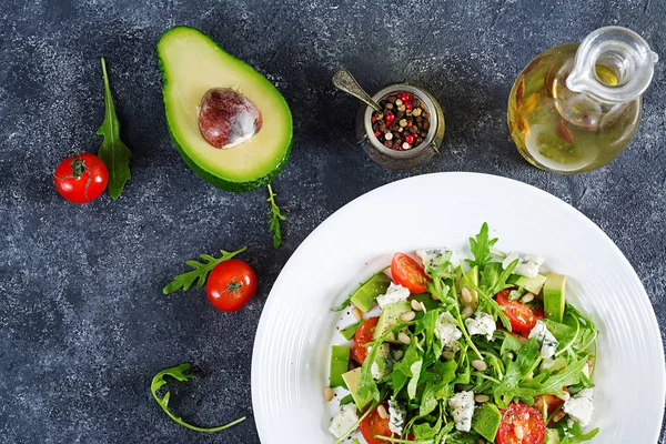 Diyet salata domates, mavi peynir, avokado, roka ve çam fıstığı. Üstten görünüm. Düz yatıyordu.