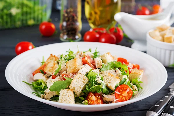 Healthy grilled chicken Caesar salad with tomatoes, cheese and croutons. North American cuisine