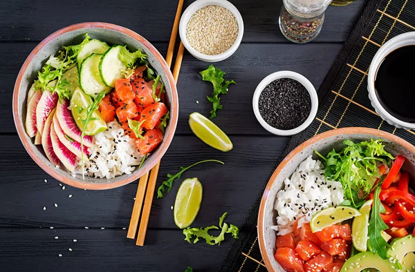 Pirinç, avakado, kırmızı biber, salatalık, turp, susam ve kireç ile Hawaiian Somon Balık poke kase. Buda kase. Diyet yemekleri. Üstten görünüm