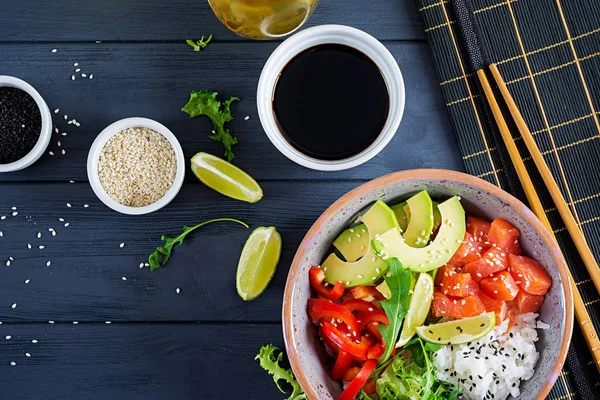 Hawaii somon balığı kasesi, pilav, avokado, paprika, susam tohumu ve limon. Buda kasesi. Diyet yemek. Üst görünüm