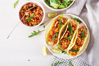 Meksika tacos tavuk eti, Mısır ve domates sos ile. Latin Amerika mutfağı. Taco, tortilla, şal. Üstten görünüm. Düz yatıyordu