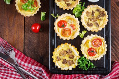 Mantar, kaşar peyniri, domates tartlets ahşap arka plan üzerinde. Mini turta. Lezzetli meze, tapas, Aperatif. Üstten görünüm. Düz yatıyordu