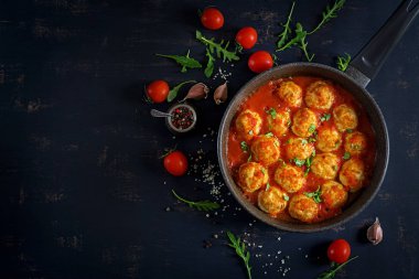 Tablo üzerinde tavada domates soslu tavuk köfte