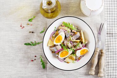 Geleneksel salata tuzlu ringa balığı filetosu, taze elma, kırmızı soğan ve yumurta. Kaşer gıda. İskandinav Mutfağı. Üstten görünüm. Düz yatıyordu