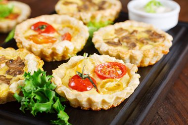 Mantar, kaşar peyniri, domates tartlets ahşap arka plan üzerinde. Mini turta. Lezzetli meze, tapas, snack.