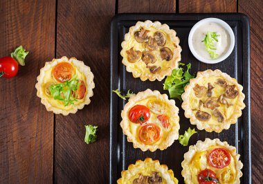 Mantar, kaşar peyniri, domates tartlets ahşap arka plan üzerinde. Mini turta. Lezzetli meze, tapas, Aperatif. Üstten görünüm. Düz yatıyordu