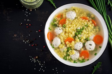 İtalyan köfteli çorba ve Stelline gluten ücretsiz makarna kase siyah masada. Diyet çorbası. Bebek menü. Lezzetli yemekler. Üstten görünüm. Kopya alanı