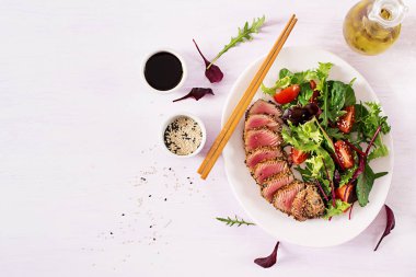Bir plaka üzerinde taze sebze salatası ile Japon geleneksel salata adet pişmiş Izgara Ahi tuna ve susam ile. Otantik Japon yemekleri. Üstten görünüm. Kopya alanı.