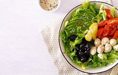 Taze salata avokado, domates, zeytin ve mozzarellalı bir kase. Buda kase. Fitness Gıda. Vejetaryen yemek. Üstten görünüm