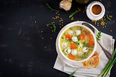 İtalyan köfteli çorba ve Stelline makarna kase siyah masada. Diyet çorbası. Bebek menü. Lezzetli yemekler. Üstten görünüm. Kopya alanı