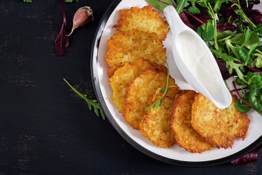 Patates kızartması/draniki/krep ekşi krema ile servis. Avrupa mutfağı. Koşer yeme. Vegan gıda. Üstten görünüm, düz yatıyordu, kopya alanı