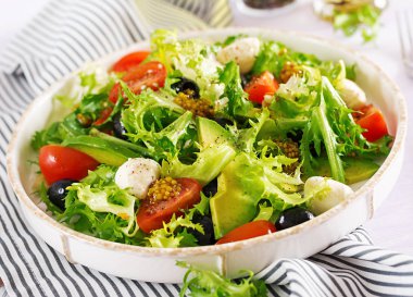 Taze salata avokado, domates, zeytin ve mozzarellalı bir kase. Fitness Gıda. Vejetaryen yemek.