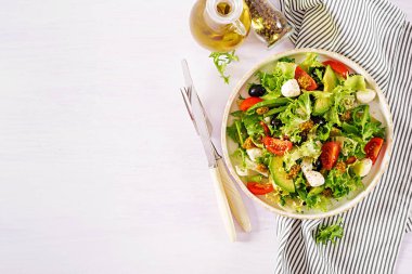 Taze salata avokado, domates, zeytin ve mozzarellalı bir kase. Fitness Gıda. Vejetaryen yemek. Üstten görünüm