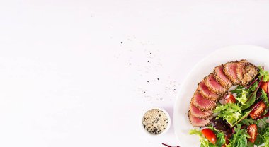 Bir plaka üzerinde taze sebze salatası ile Japon geleneksel salata adet pişmiş Izgara Ahi tuna ve susam ile. Otantik Japon yemekleri. Üstten görünüm. Afiş. Kopya alanı.