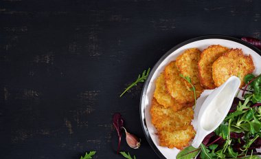 Patates kızartması/draniki/krep ekşi krema ile servis. Avrupa mutfağı. Koşer yeme. Vegan gıda. Üstten görünüm, düz yatıyordu, kopya alanı