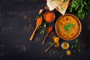 Hint dal. Gıda. Geleneksel Hint çorbası mercimek. Hint Dhal baharatlı köri kase, baharatlar, bitkiler, rustik siyah ahşap arka plan. Üstten Görünüm. Otantik Hint yemeği. Yükü. Düz yatıyordu