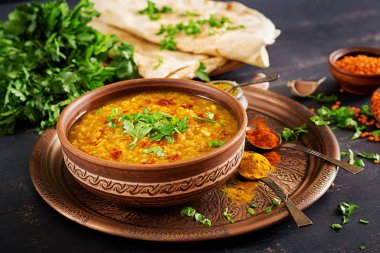 Hint dal. Geleneksel Hint çorbası mercimek. Hint Dhal baharatlı köri kase, baharatlar, bitkiler, rustik siyah ahşap arka plan. Otantik Hint yemeği. Ek yük