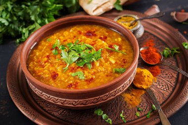 Hint dal. Geleneksel Hint çorbası mercimek. Hint Dhal baharatlı köri kase, baharatlar, bitkiler, rustik siyah ahşap arka plan. Otantik Hint yemeği. Ek yük