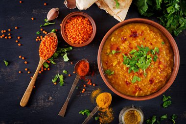 Hint dal. Gıda. Geleneksel Hint çorbası mercimek. Hint Dhal baharatlı köri kase, baharatlar, bitkiler, rustik siyah ahşap arka plan. Üstten Görünüm. Otantik Hint yemeği. Yükü. Düz yatıyordu