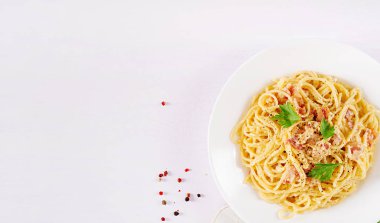 Classic homemade carbonara pasta with pancetta, egg, hard parmesan cheese and cream sauce. Italian cuisine. Spaghetti alla carbonara. Top view, flat lay, copy space
