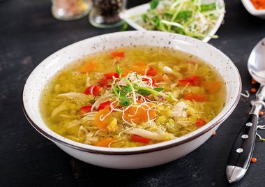 Mercimek, havuç, tavuk eti, kırmızı biber, kereviz bir kase çorba.