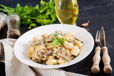 Gnocchi maydanoz koyu arka plan üzerinde bir kapta bir mantar krema sos ile