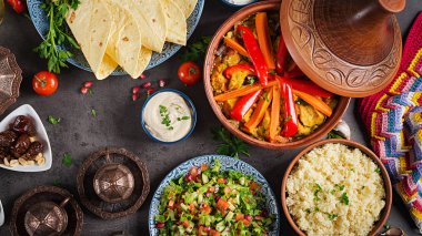 Fas yemeği. Geleneksel tajine yemekler, kuskus ve rustik ahşap masa üzerinde taze salata. Tagine tavuk eti ve sebze. Arap mutfağı. Üstten Görünüm. Düz yatıyordu