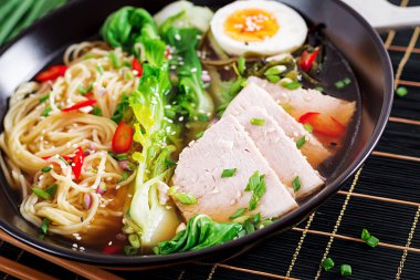 Koyu arka plan üzerinde bir kapta yumurta, domuz eti ve pak choi lahana ile miso Ramen Asya erişte. Japon mutfağı.