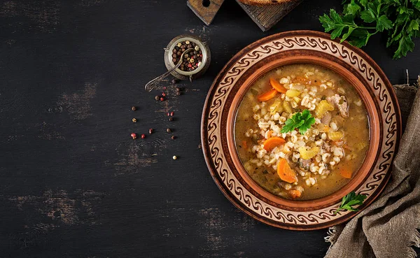 Barley soup with carrots, tomato, celery and meat on a dark background. Top view. — Stock Image Barley Soup Carrots Tomato Celery Meat Dark Background Top View Stock Picture