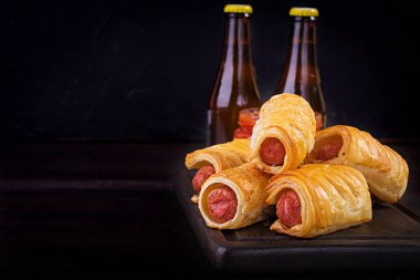 Domates soslu bir ahşap tahta üzerinde hamur sosis