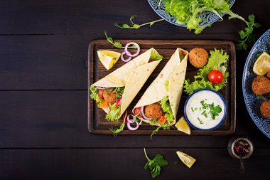 Falafel ve taze salata tortilla sarın. Vegan Taco. Vejetaryen sağlıklı yiyecekler. Üstten Görünüm