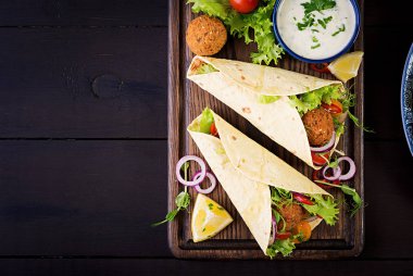 Falafel ve taze salata tortilla sarın. Vegan Taco. Vejetaryen sağlıklı yiyecekler. Üstten Görünüm