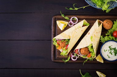 Falafel ve taze salata tortilla sarın. Vegan Taco. Vejetaryen sağlıklı yiyecekler. Üstten Görünüm