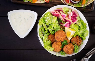 Falafel ve taze sebze. Buda kase. Karanlık bir arka plan üzerinde Orta Doğu ya da Arap yemekleri. Helal Gıda. Üstten Görünüm. Kopya alanı