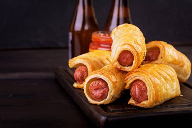 Domates soslu bir ahşap tahta üzerinde hamur sosis