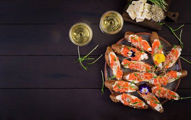 Somon Sandviç ile krem peynir ve ahşap masa üzerinde microgreen. Somon kanepe. Üstten Görünüm