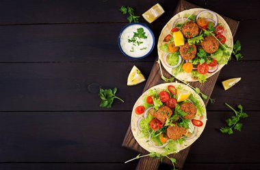 Falafel ve taze salata tortilla sarın. Vegan Taco. Vejetaryen sağlıklı yiyecekler. Üstten Görünüm
